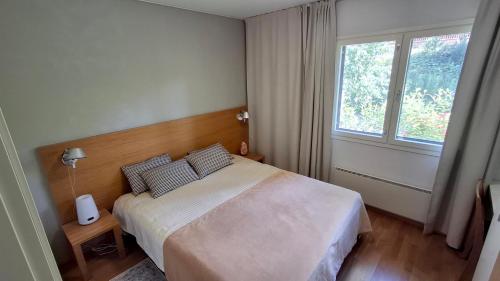 a bedroom with a bed and a window at Saimaan Rantavilla Zebra in Imatra