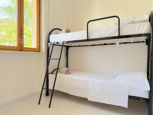 two bunk beds in a room with a window at Villetta Chiara in Baia Verde