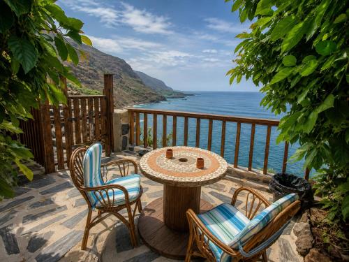 a patio with a table and chairs and the ocean at TenoHomes La Era de Catuja Getaway in Los Realejos