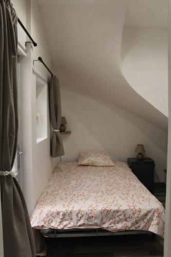 a small bedroom with a bed with a floral bedspread at Appartement MIFA in Frontignan