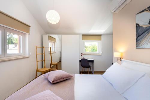 a bedroom with a bed and a desk and a chair at Villa Egli s bazenom in Kršan