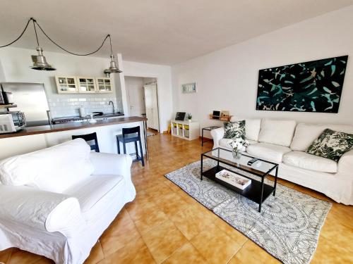 a living room with a white couch and a table at Teguisol Breeze en Costa Teguise in Costa Teguise