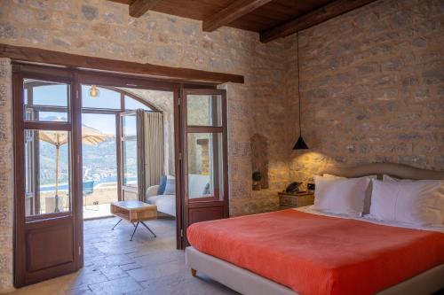 a bedroom with a bed and a door to a patio at Petra & Fos Boutique Hotel & Spa in Neo Itilo