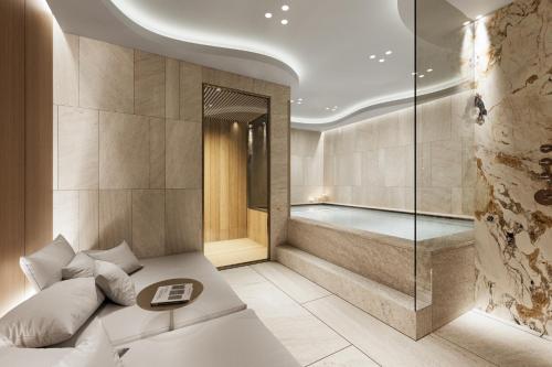 a spa room with a tub and a bed at Campiglio PLAZA in Madonna di Campiglio