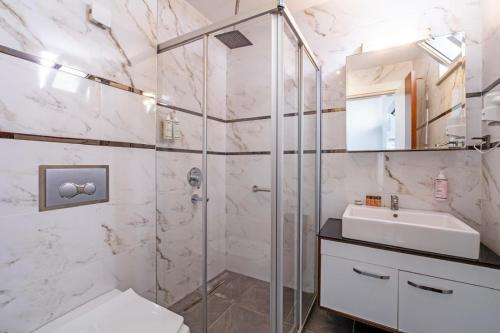 a bathroom with a glass shower and a sink at Hey Lara Hotel in Antalya