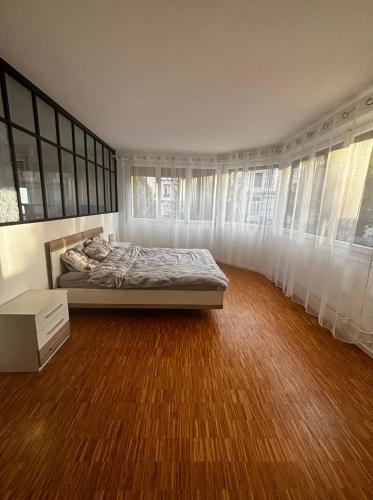Ein Schlafzimmer mit einem Bett, weißen Vorhängen und Holzboden in der Unterkunft Shiraz in Lausanne