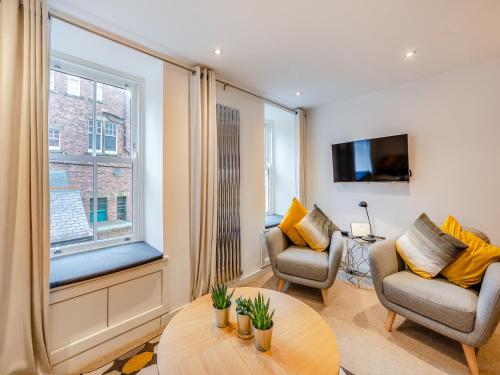 a living room with two chairs and a table at Town Square House - Uk45610 in Alnwick