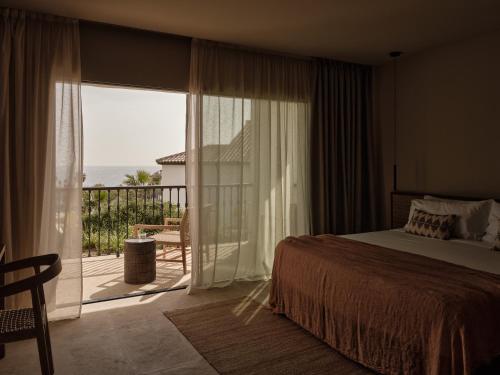 a bedroom with a bed and a balcony with a view at OKU Andalusia in La Alcaidesa