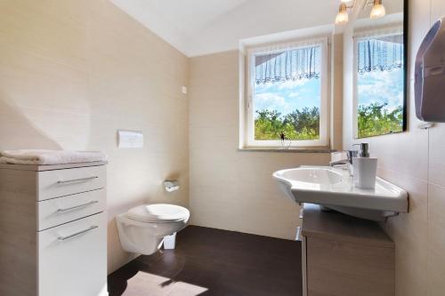 a bathroom with a sink and a toilet and a window at Reiterhof Siglgut in Laces