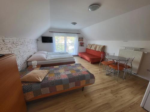 a bedroom with two beds and a table and a couch at Apartmány BOSS in Liptovský Mikuláš