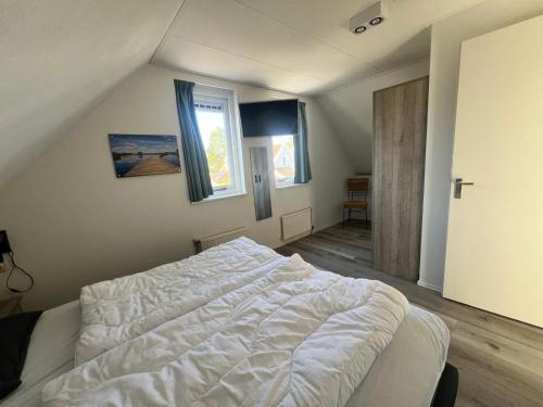 a bedroom with a white bed in a attic at Aquadelta - Casa Claudia in Bruinisse