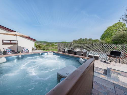 a swimming pool in a yard with a patio at Wheelwright Barn in Llangain