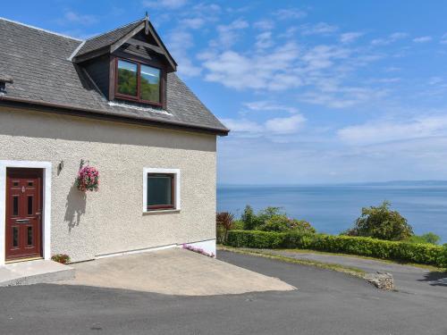 a house with a window and a view of the ocean at Woodlea Cottage 1 in Dippin