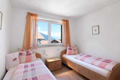 two beds in a room with a window at Reiterhof Siglgut in Laces