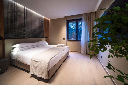a bedroom with a bed and a potted plant at Sant'Angela Rooms in Foligno