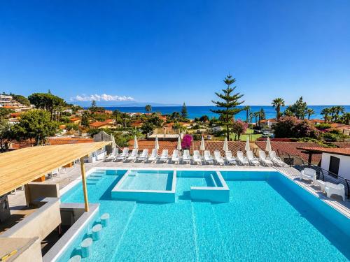 a swimming pool with chairs and the ocean in the background at Ninfa Sul Mare Apartments - Piscina con Area Relax e Parcheggio Gratuito in Capo Vaticano