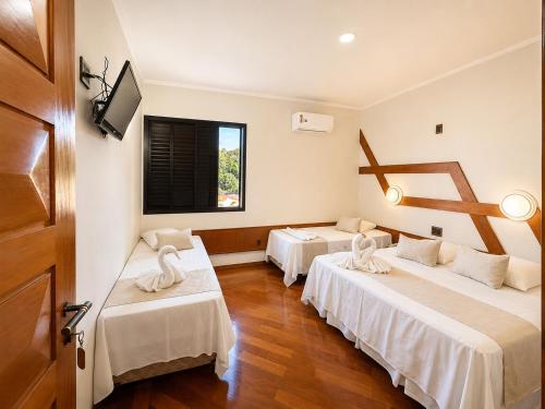 a hotel room with two beds and a window at Serra Negra Paladium Hotel in Serra Negra