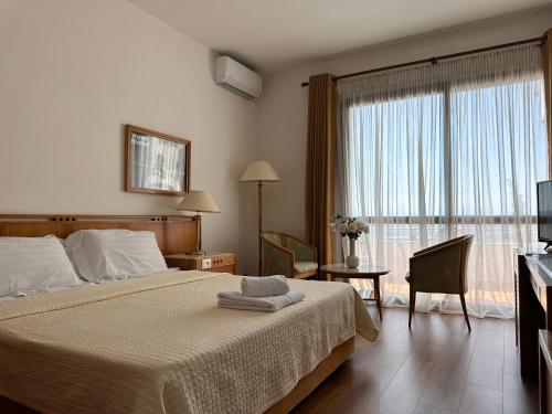 a bedroom with a bed and a large window at Chateau Linza Resort in Tirana