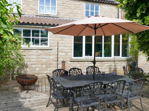 a black table and chairs with an umbrella at Rose Croft in Pickering