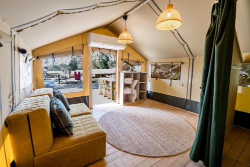 a living room with a couch and a rug at Katzrin Village Glamping in Qasrîne