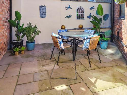 a patio with a table and chairs and plants at Dunlin in Filey