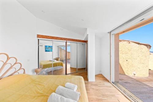 a bedroom with a view of a bed and a mirror at "maison calypso" in Hyères