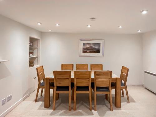a dining room with a wooden table and chairs at Faodail in Plockton