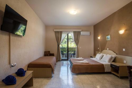 a hotel room with two beds and a television at Santa Helena Hotel in Ialysos