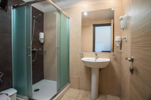 a bathroom with a shower and a sink and a shower at Santa Helena Hotel in Ialysos