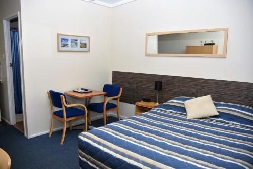Un pat sau paturi într-o cameră la Chinchilla Motel