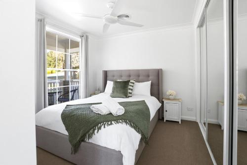 a bedroom with a bed and a window at Blue Willow Cottage - Bathurst in Bathurst