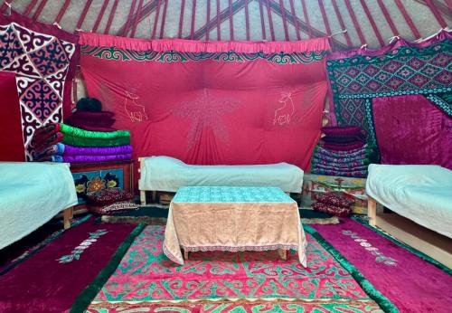 a room with beds and a rug in a yurt at "AlmUrUt" Guest House in Bokonbayevo