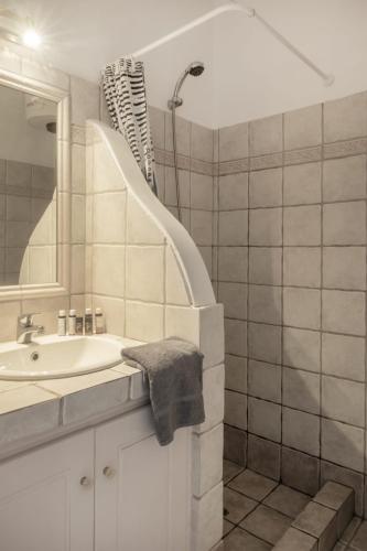 a white bathroom with a sink and a shower at Lefkanemos in Tourlos