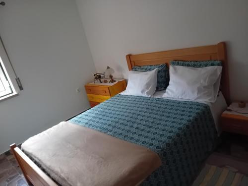 a bedroom with a bed with a blue and white comforter at Cantinho Verde in Sertã