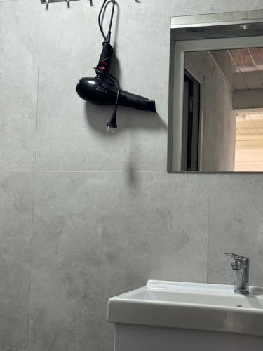 a bathroom with a black light hanging on the wall at "AlmUrUt" Guest House in Bokonbayevo