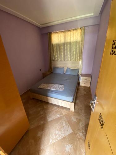 a small bedroom with a bed and a window at La ferme labyed in Fez
