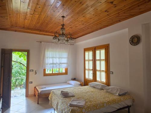 a bedroom with two beds and a wooden ceiling at LATE Nature House Gjirokaster in Gjirokastër