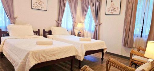 a room with two beds with white sheets and windows at 90 9 Pool Villa Chiang Mai in Ban Pa Ngae