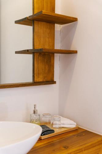 a bathroom with wooden shelves and a sink at Kainos Tropical Boutique Hotel in Las Terrenas