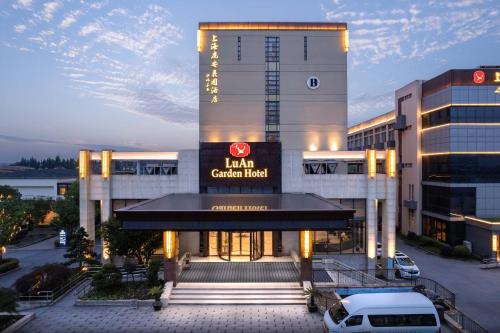 a building with a car parked in front of it at ShangHai LuAn Garden Hotel-Complimentary shuttle service between Shanghai Pu d ong Airport and Disneyland in Shanghai