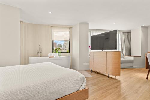 a bedroom with a bed and a flat screen tv at Nodo Hotel in Manizales