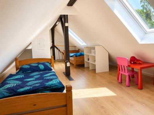 a bedroom with a bed and a desk in a attic at Chata pod Jilmy in Pelhřimov