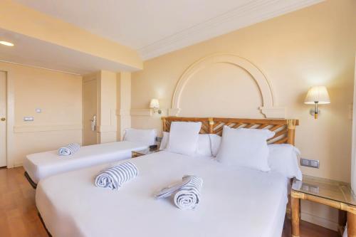 two beds in a hotel room with white pillows at Moon Dreams Portomagno in Aguadulce