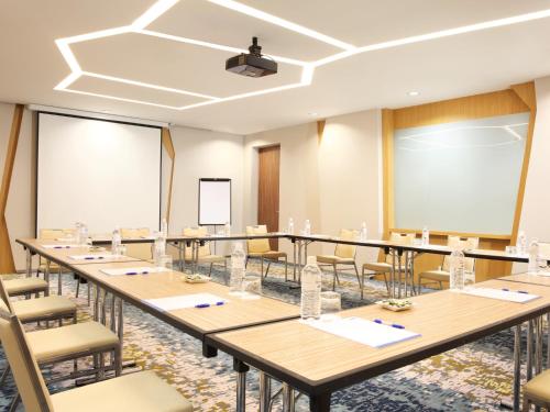a conference room with tables and chairs and a podium at Holiday Inn Express Baruna by IHG in Kuta