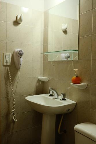 a bathroom with a sink and a mirror and a toilet at Cabañas Yunyay in Villa Cura Brochero