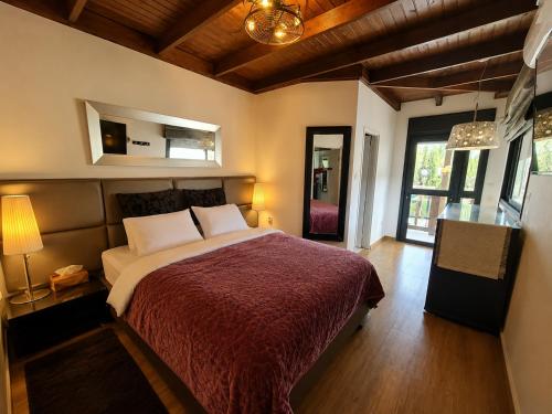 a bedroom with a large bed with a red blanket at וילה מקסים בחוסן - וילה מהממת עם בריכה, ג'קוזי וסאונה in H̱osen