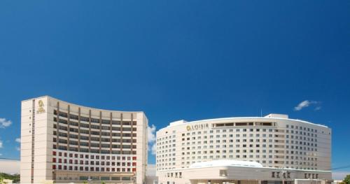 two tall white buildings next to each other at Loisir Hotel Naha in Naha