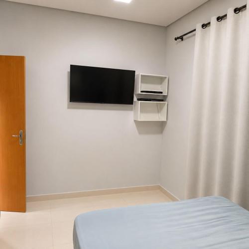 a room with a bed and a tv on a wall at Anápolis city in Anápolis