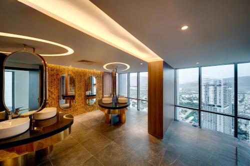 a bathroom with two sinks and mirrors and windows at Nha Trang Oceanview Suites in Nha Trang