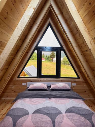 a bed in a room with a large window at Forest View Kolašin in Kolašin